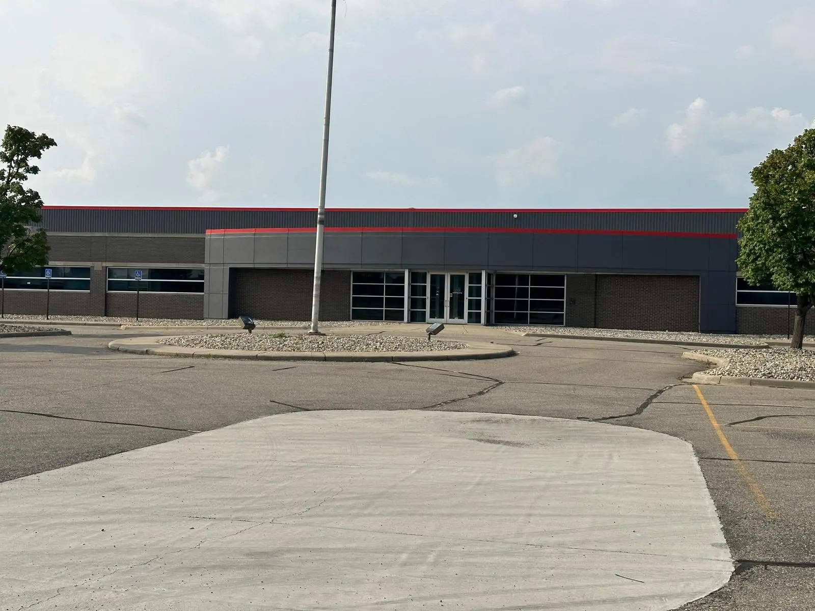 Commercial building storefront exterior with dark charcoal panels and a red accent stripe