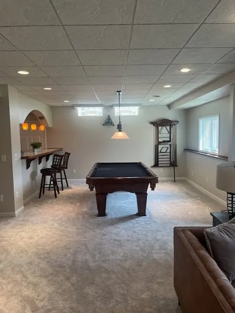 Finished basement game room with pool table, dropped ceiling tiles, and freshly painted walls