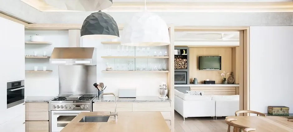Open kitchen and living room with freshly painted walls, wood cabinetry, and pendant lighting